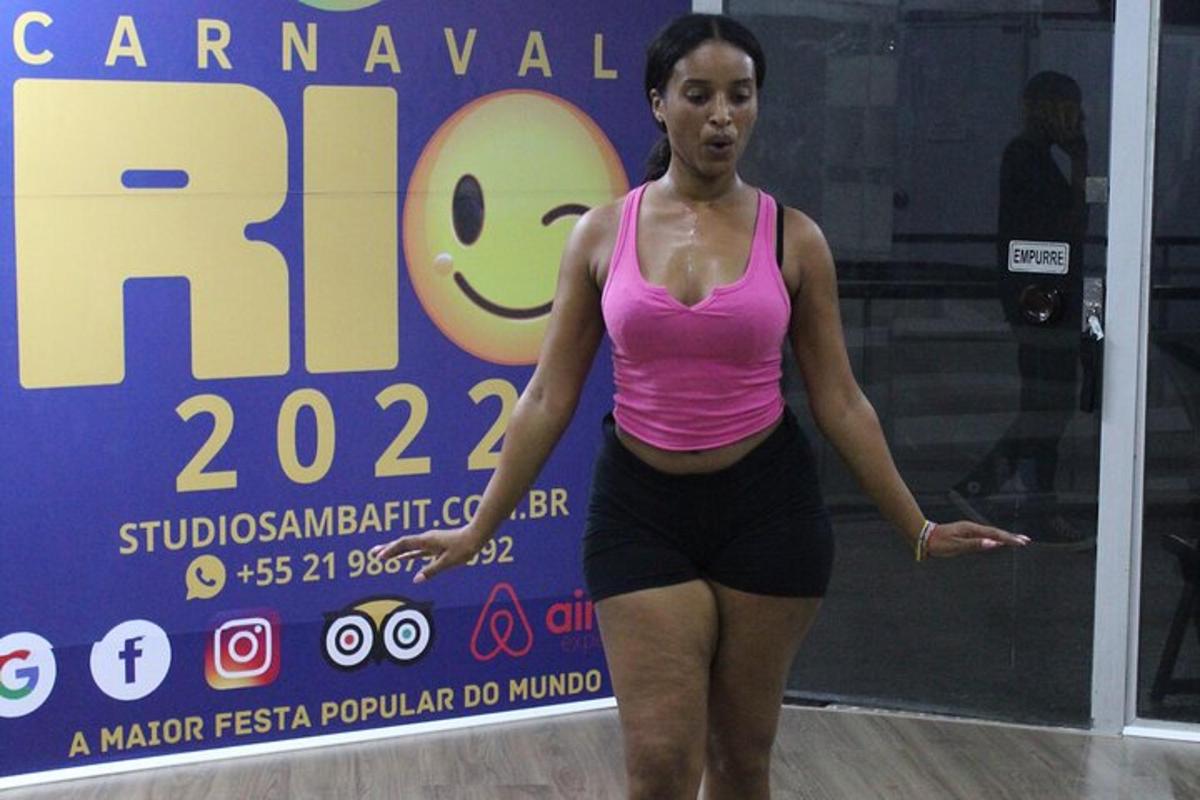 ženska v roza majici stoji pred znakom