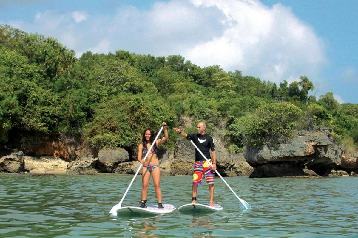 isang lalaki at isang babae sa mga paddle board sa tubig