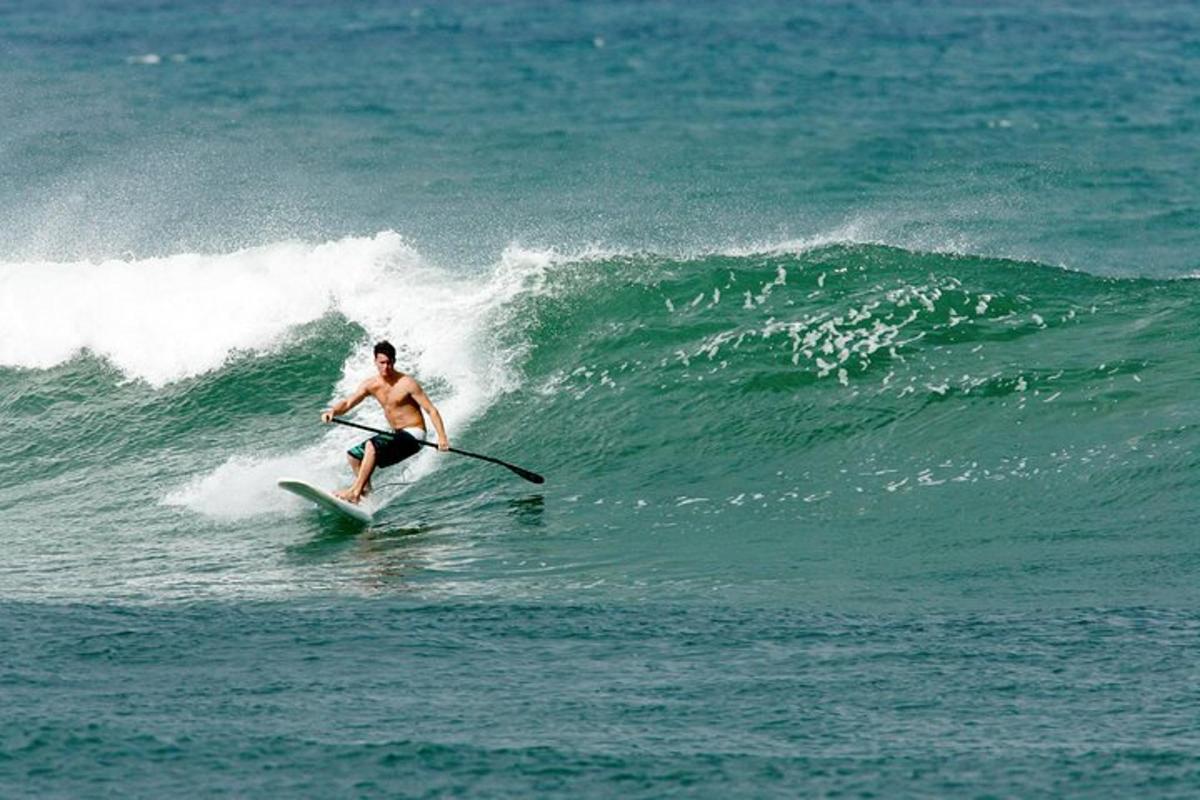 isang lalaking nakasakay sa alon sa isang surfboard sa karagatan