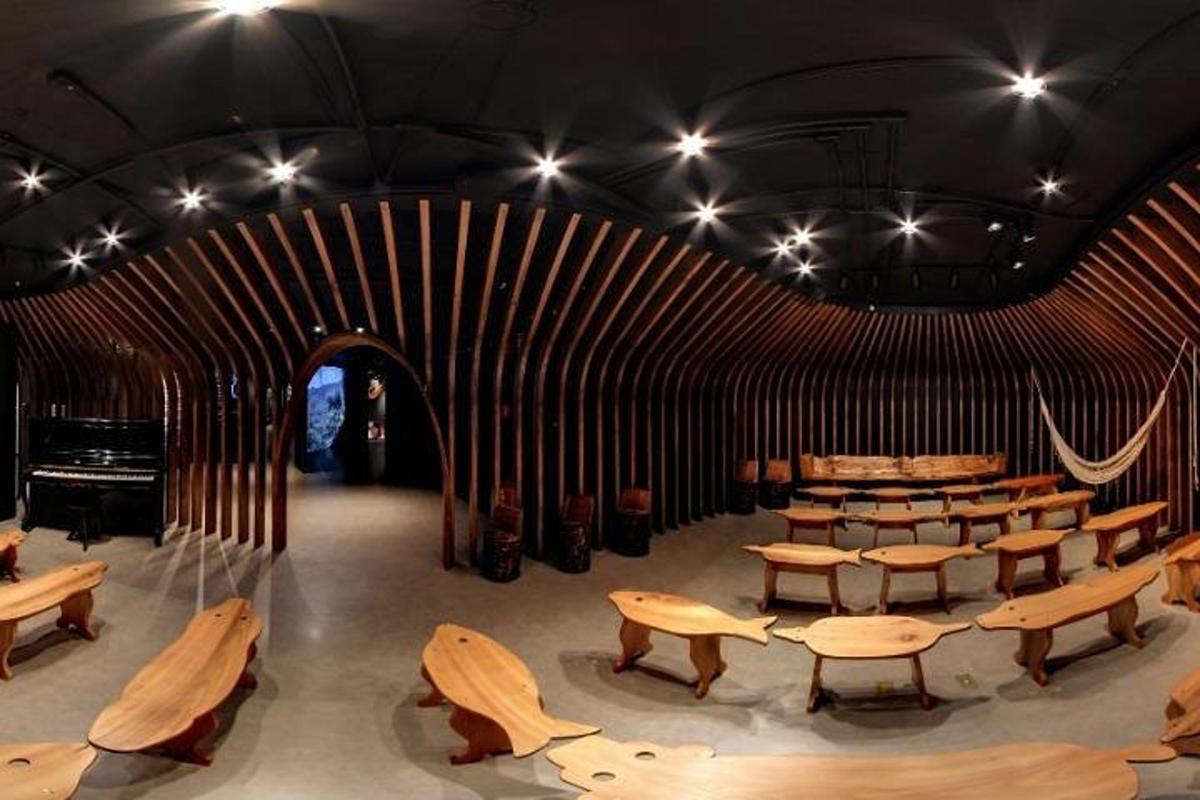 a room with wooden tables and benches and lights