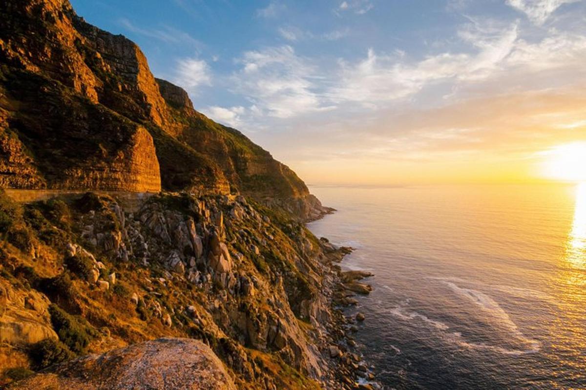 Západ slunce nad oceánem vedle skalnatého útesu