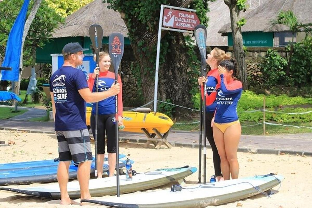 skupina lidí stojících na surfových prknech na pláži