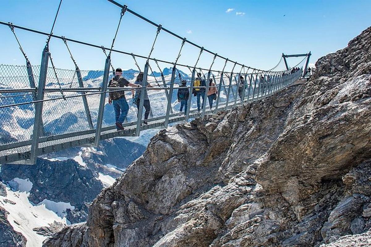 un gruppo di persone che attraversa un ponte sospeso su una montagna