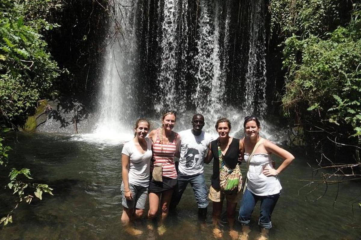 eine Gruppe von Menschen steht vor einem Wasserfall