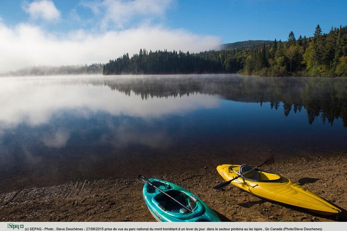 two kayaks sitting on the shore of a lake