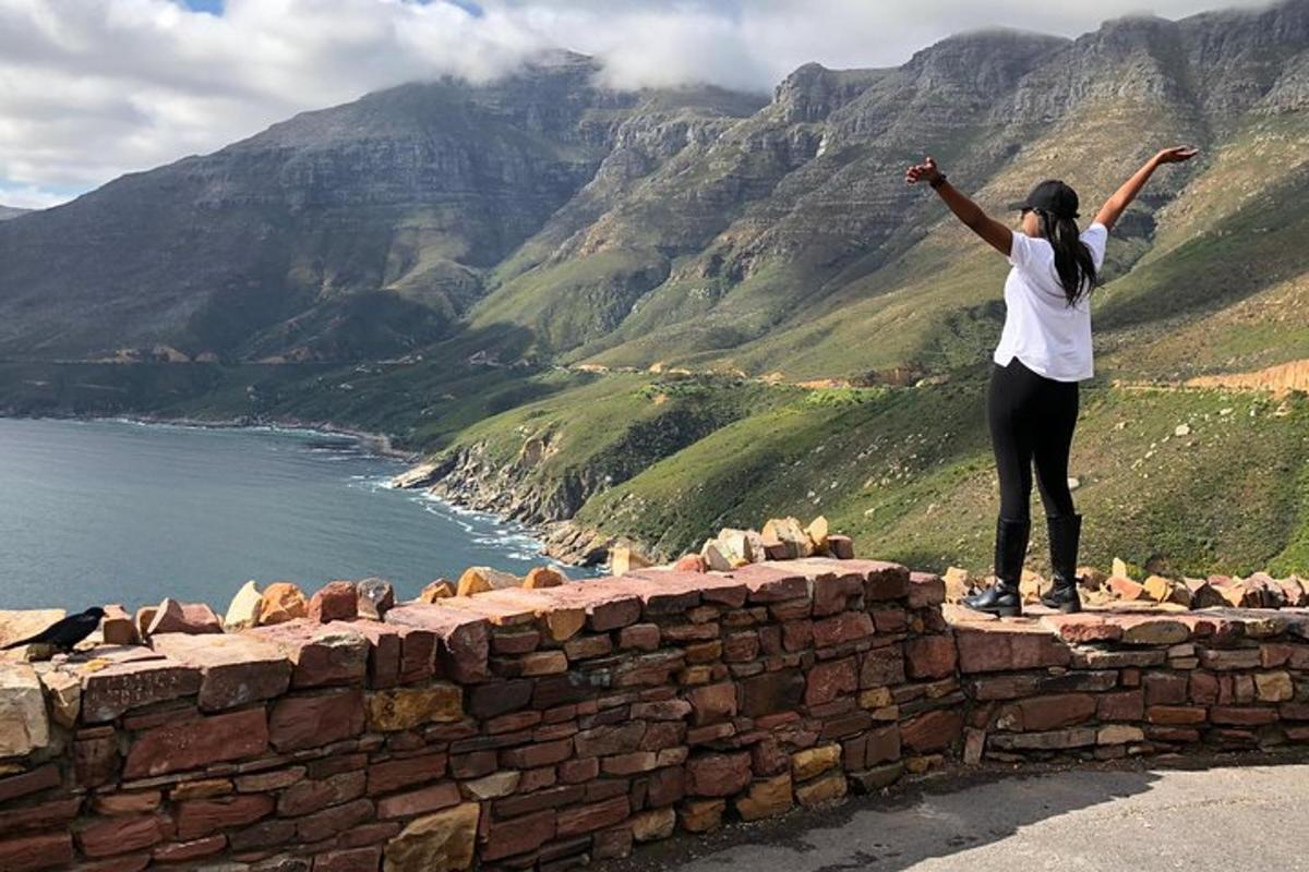 una donna in piedi in cima a un muro di mattoni con le braccia alzate