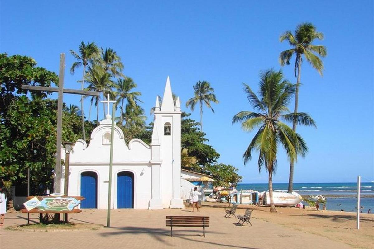 a white church on the beach with palm trees