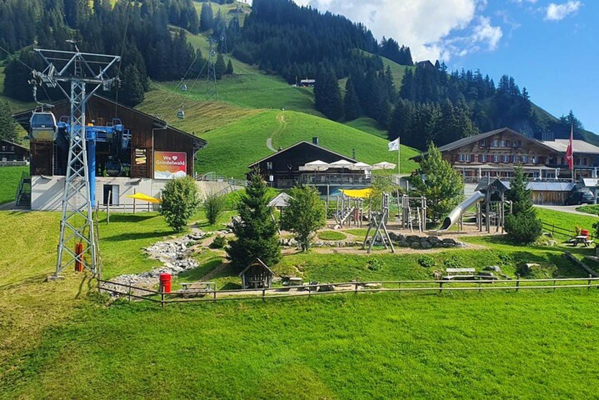 a green field with a building and a mountain