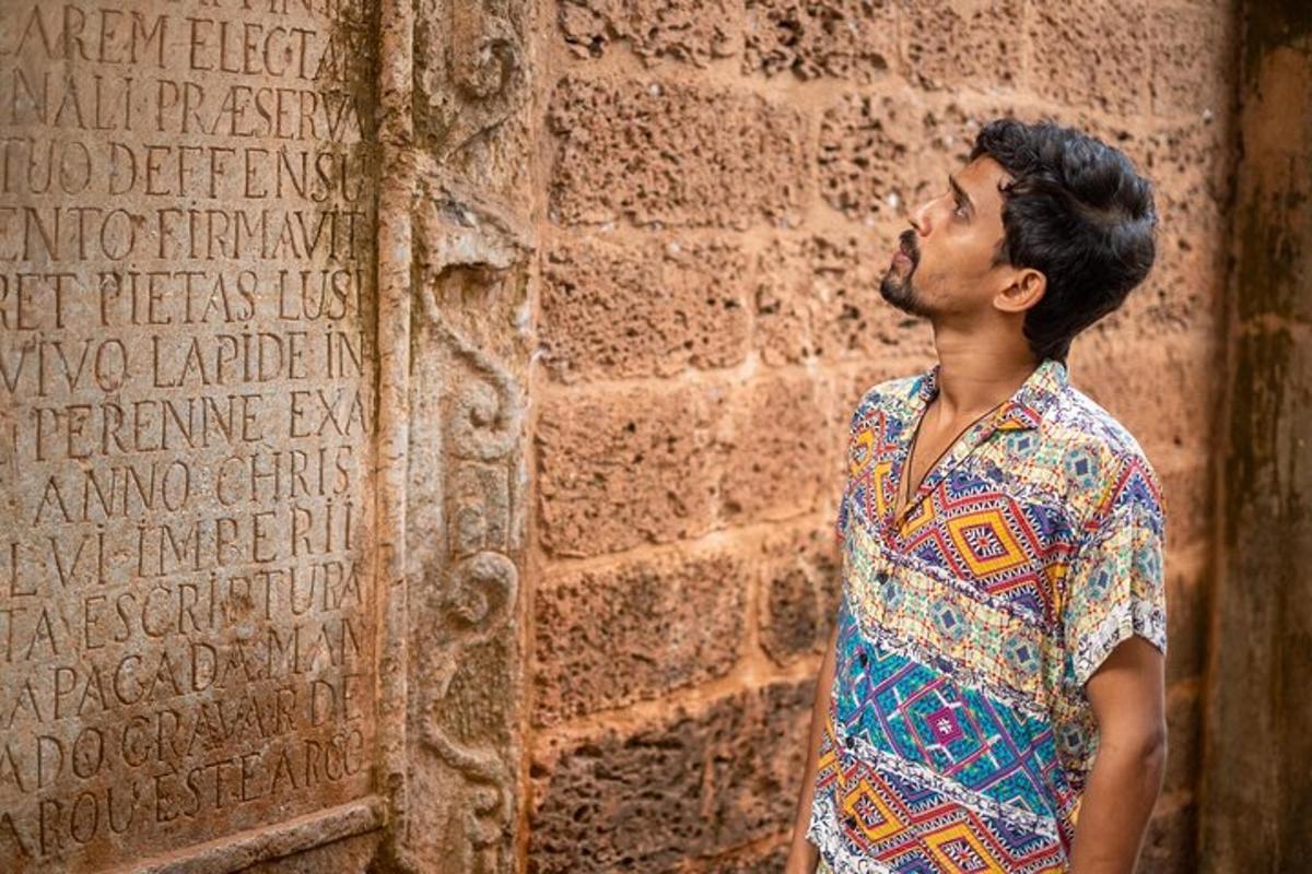 a man standing in front of a brick wall