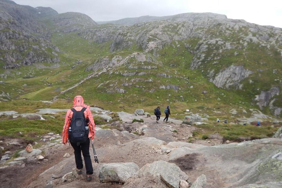 a person with a backpack walking on a mountain trail