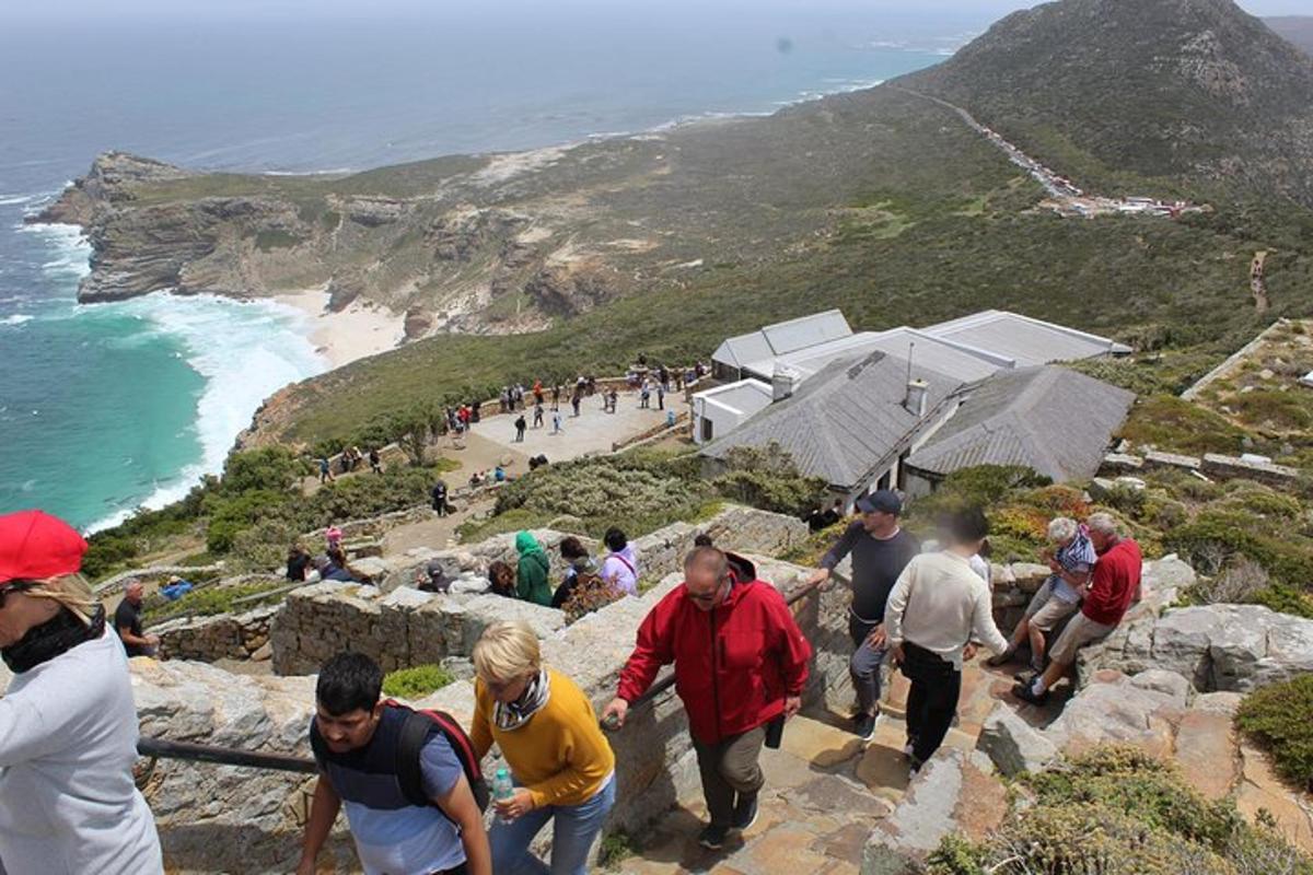 a group of people walking on the rocks near the ocean