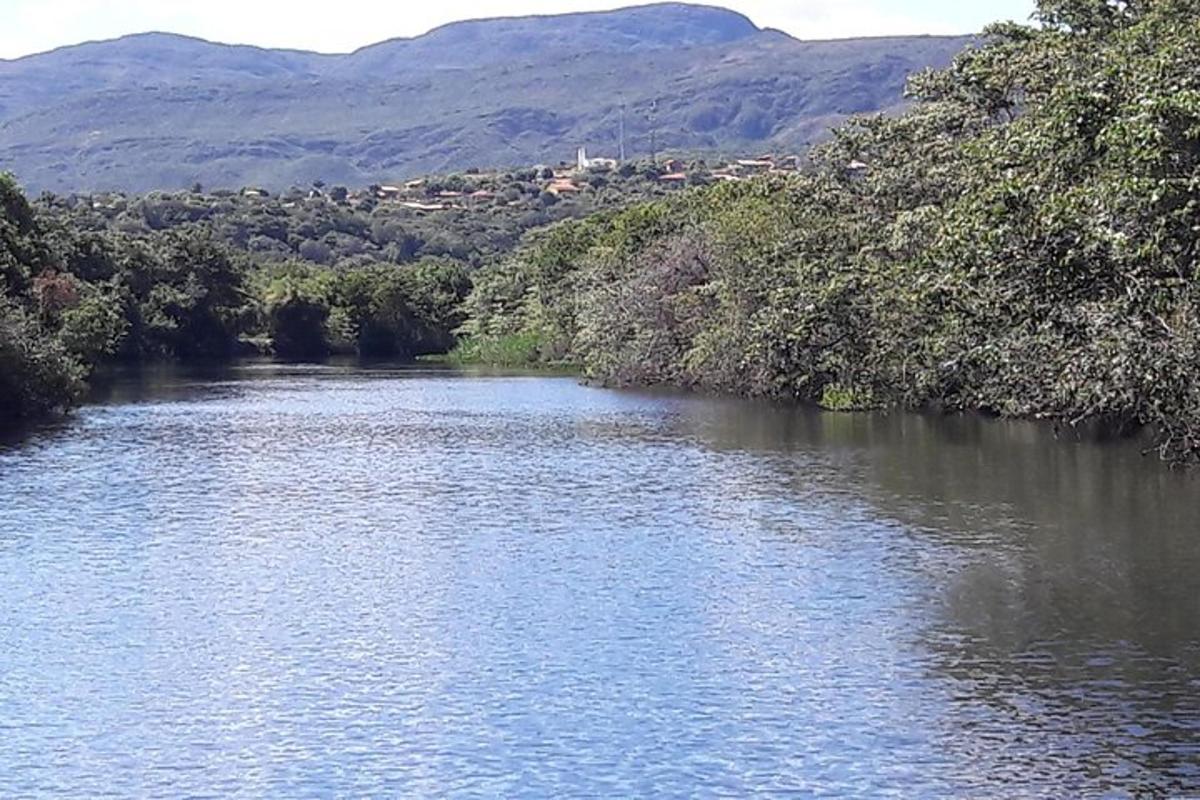 a river with trees and mountains in the background