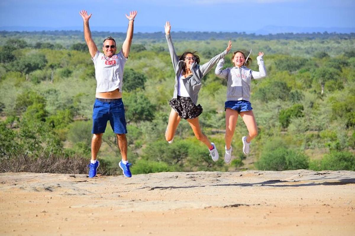 a group of three people jumping in the sand