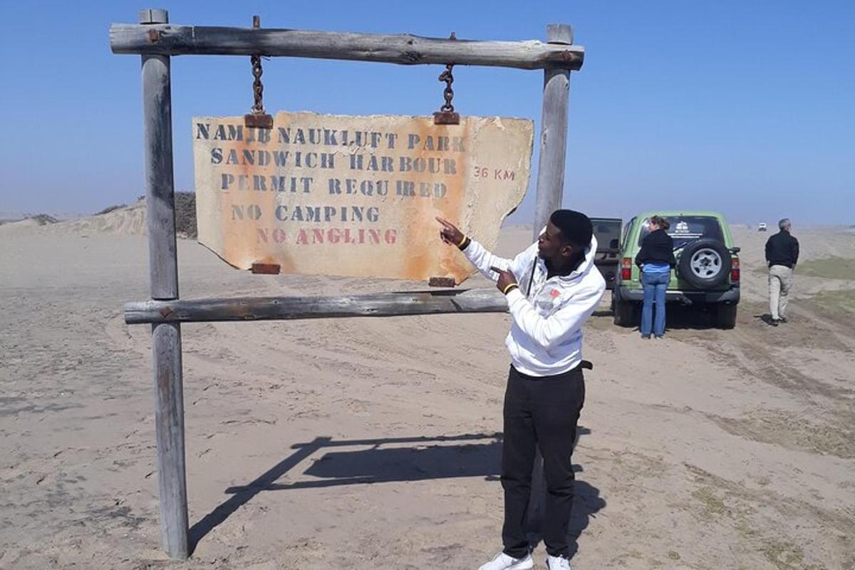 a man standing in front of a sign in the desert
