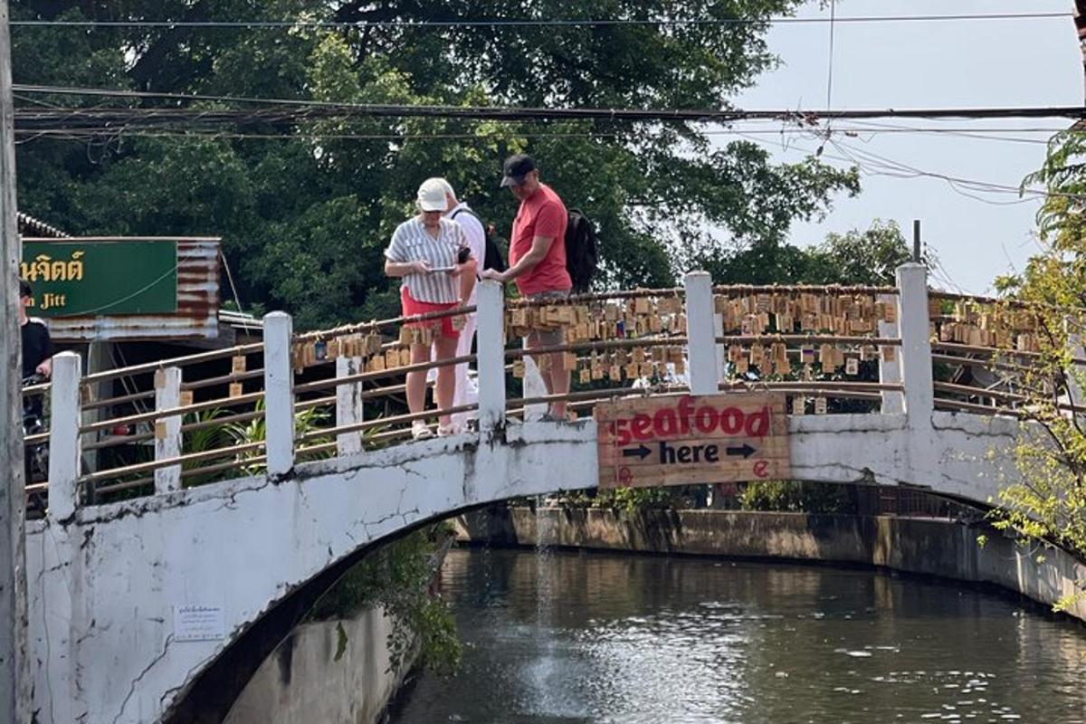 two people standing on a bridge over a river