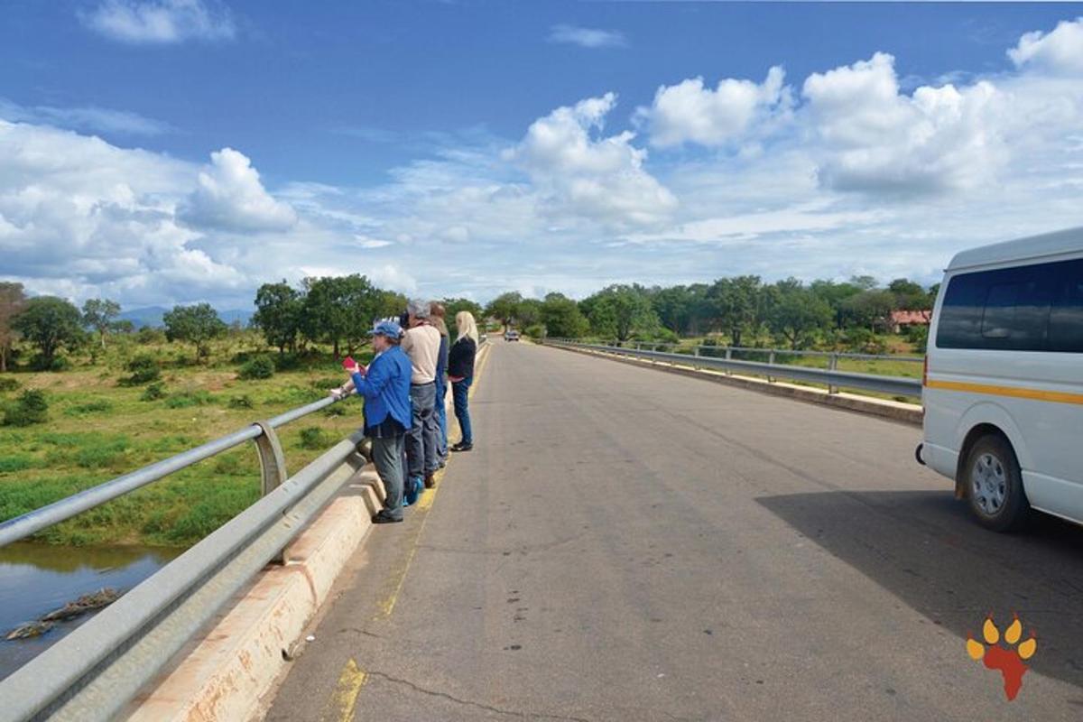 un grup de persones dretes en un pont al costat d'un autobús