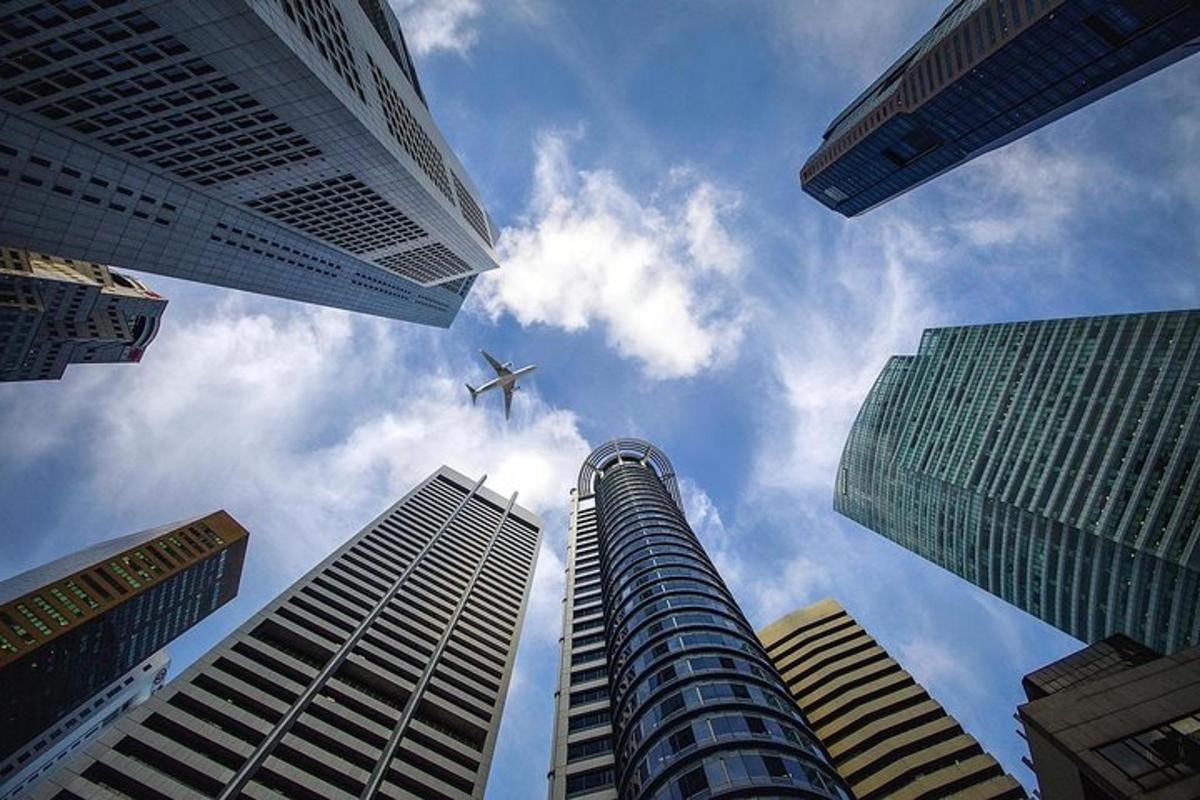 un aereo che vola nel cielo tra alti edifici