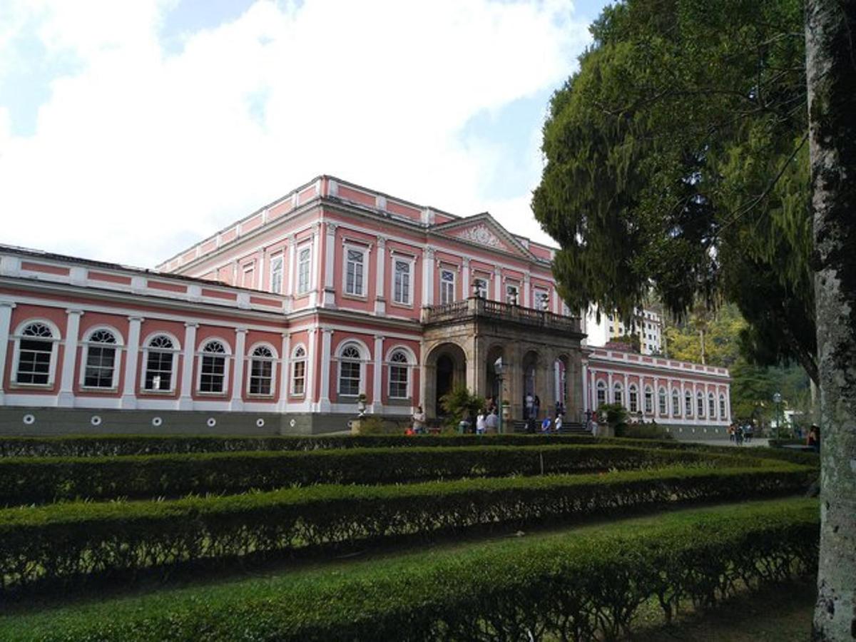 ein großes rosa Gebäude mit einem Garten davor
