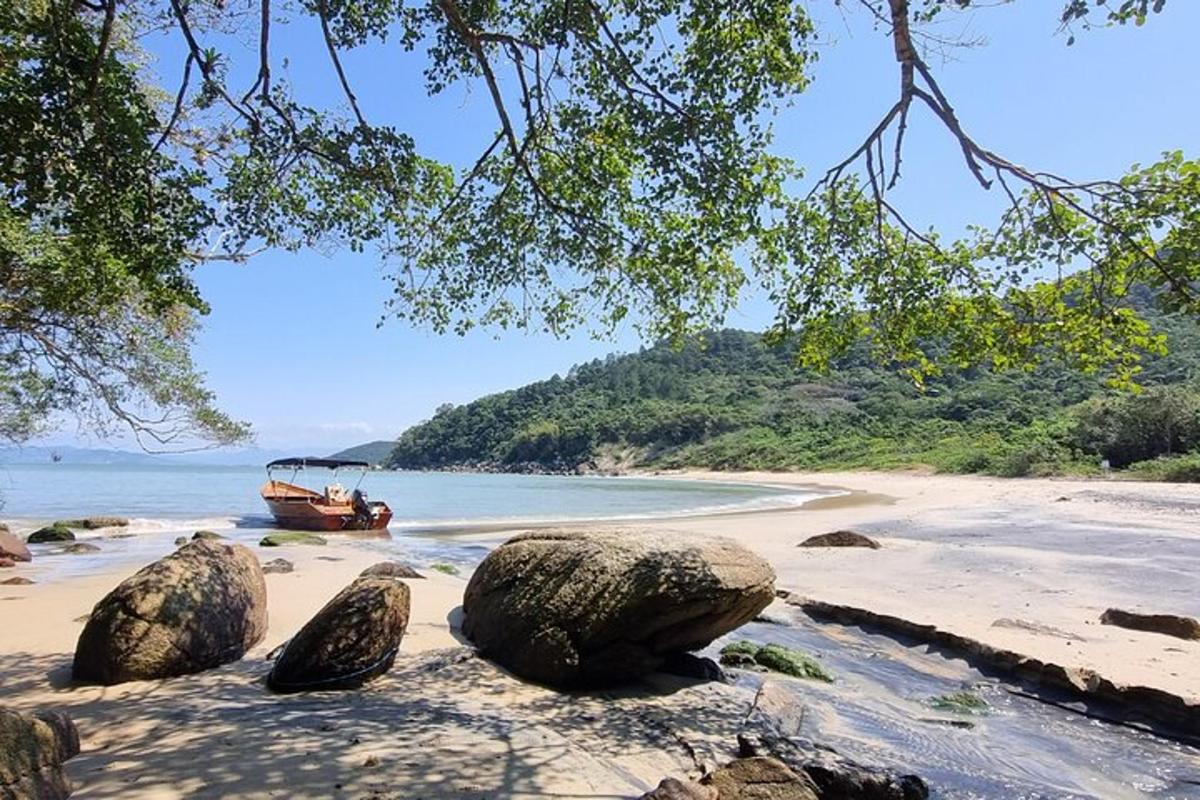 a boat on a beach with rocks on the shore