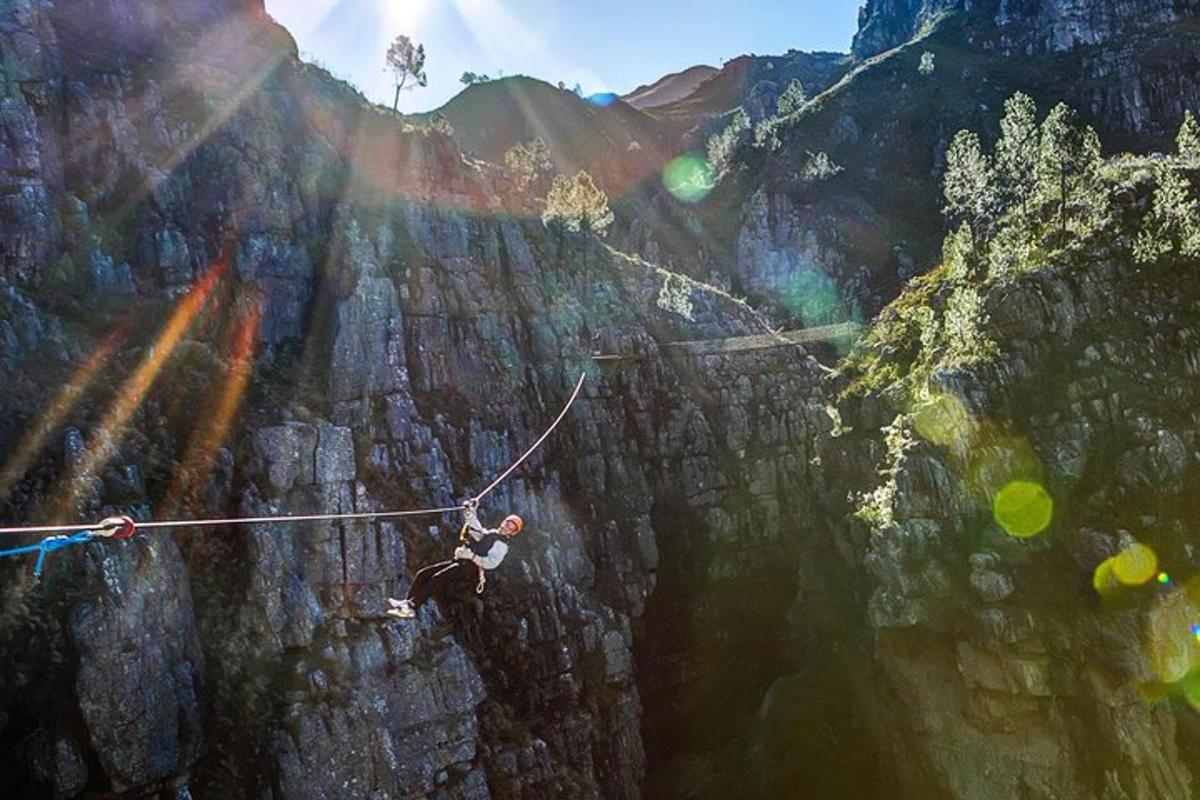 muž na zip line přes horský útes