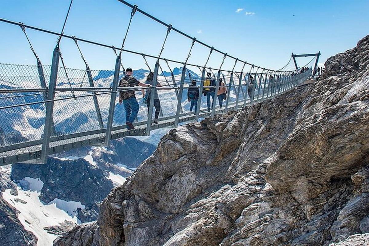 un gruppo di persone che attraversa un ponte sospeso su una montagna