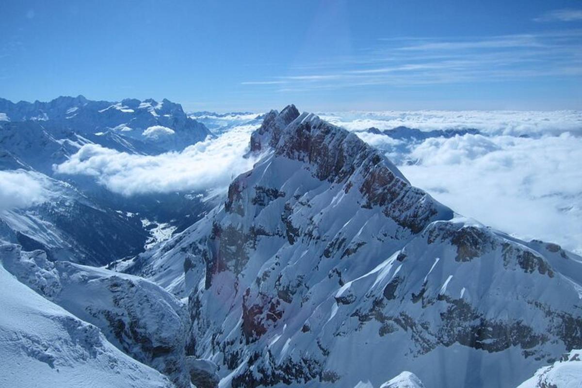 una montagna coperta di neve e nuvole nel cielo