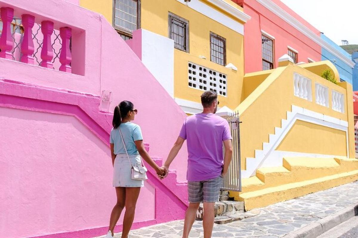 una parella agafada de la mà davant d'un edifici de colors