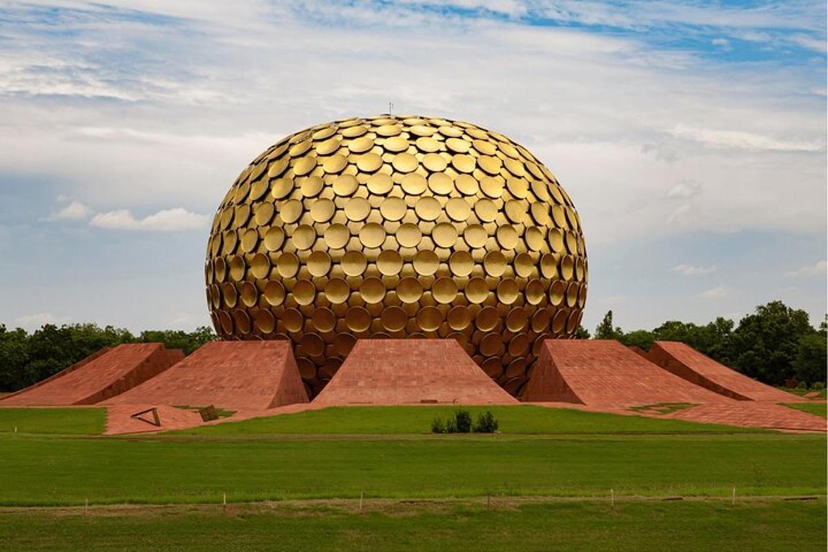 a large gold object in a field with grass