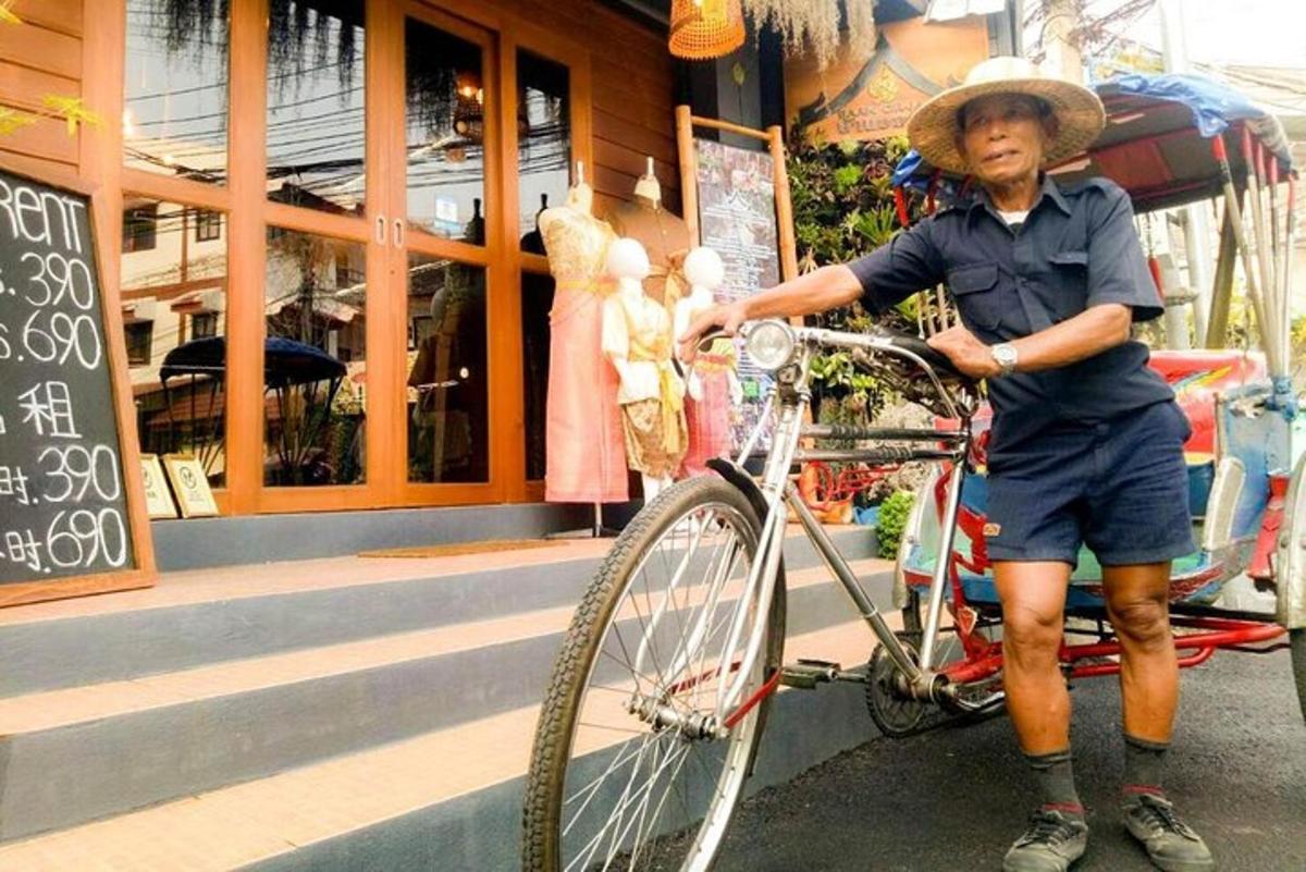 un bărbat cu pălărie stând lângă o bicicletă