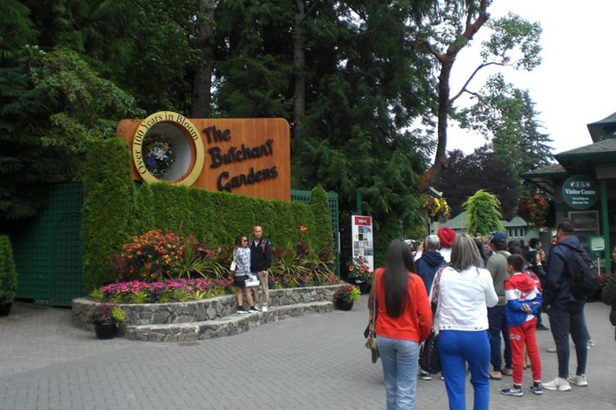 Un grupo de personas caminando frente al jardín de flores.