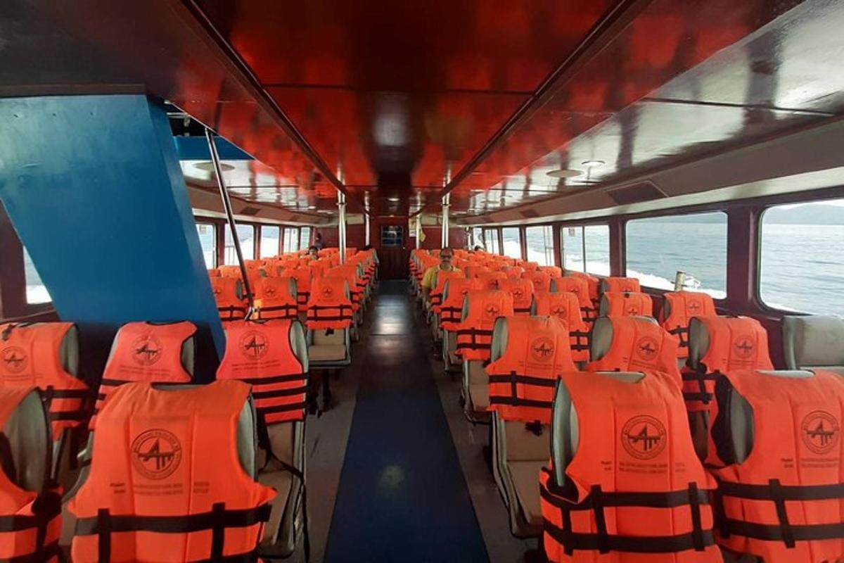 um ônibus com assentos laranja em uma balsa