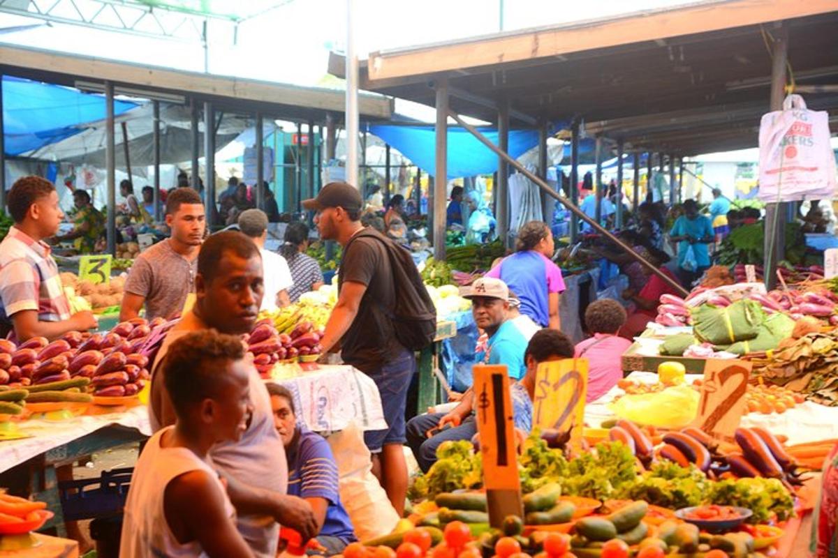 un grup de persones en un mercat amb fruites i verdures