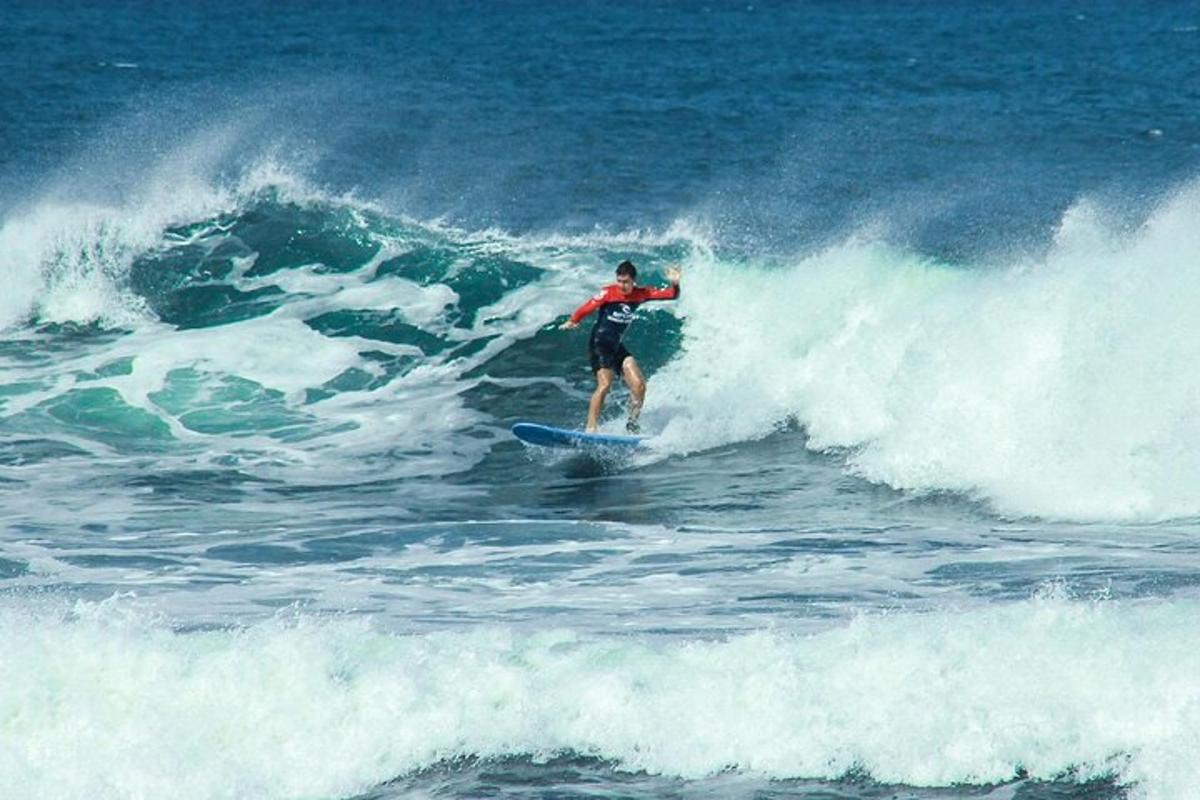un bărbat călărind un val pe o placă de surf în ocean