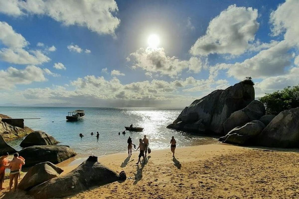 eine Gruppe von Menschen, die im Wasser an einem Strand spielen