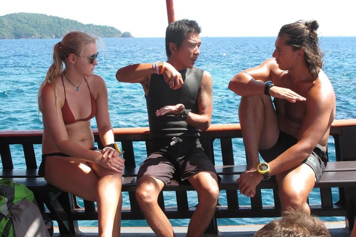 three people sitting on a bench by the water