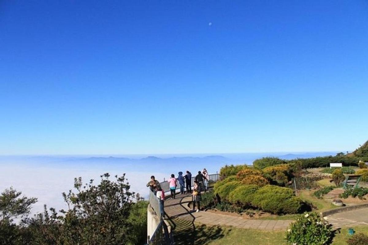 a group of people standing on a ledge overlooking the water