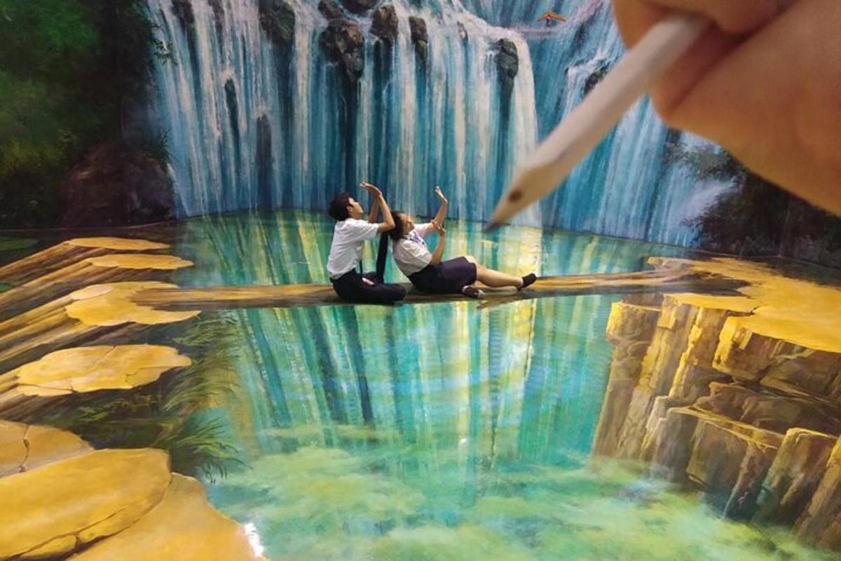 two women sitting in front of a painting of a waterfall