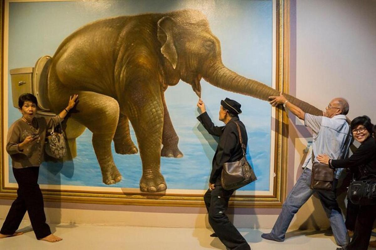 a group of people standing in front of a painting of an elephant
