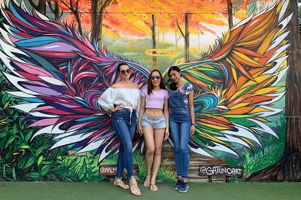 three women posing in front of a mural
