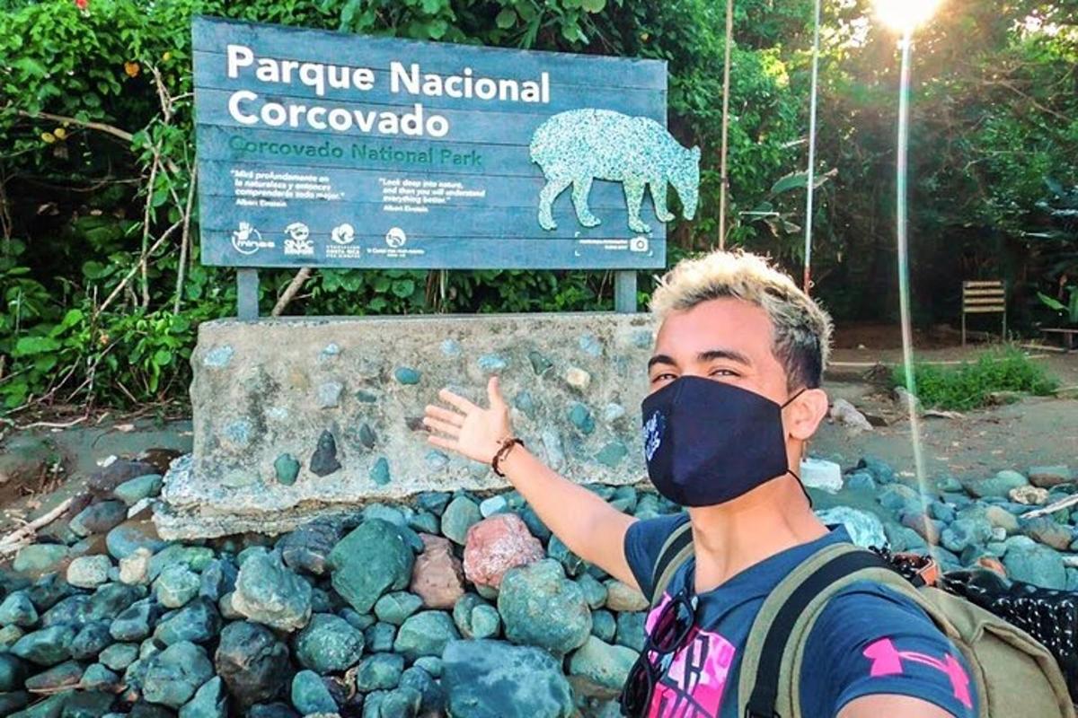 un uomo che indossa una mascherina davanti a un cartello