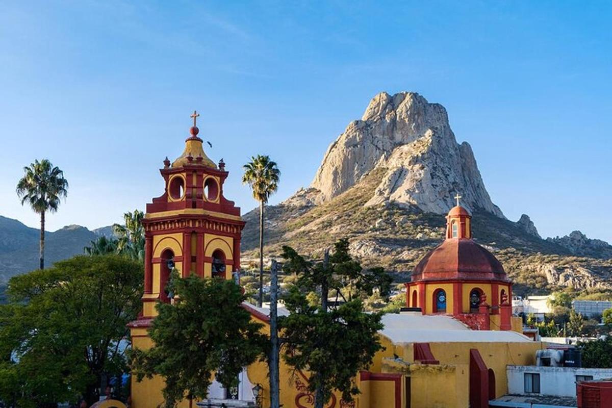sebuah gereja dan menara dengan latar belakang gunung