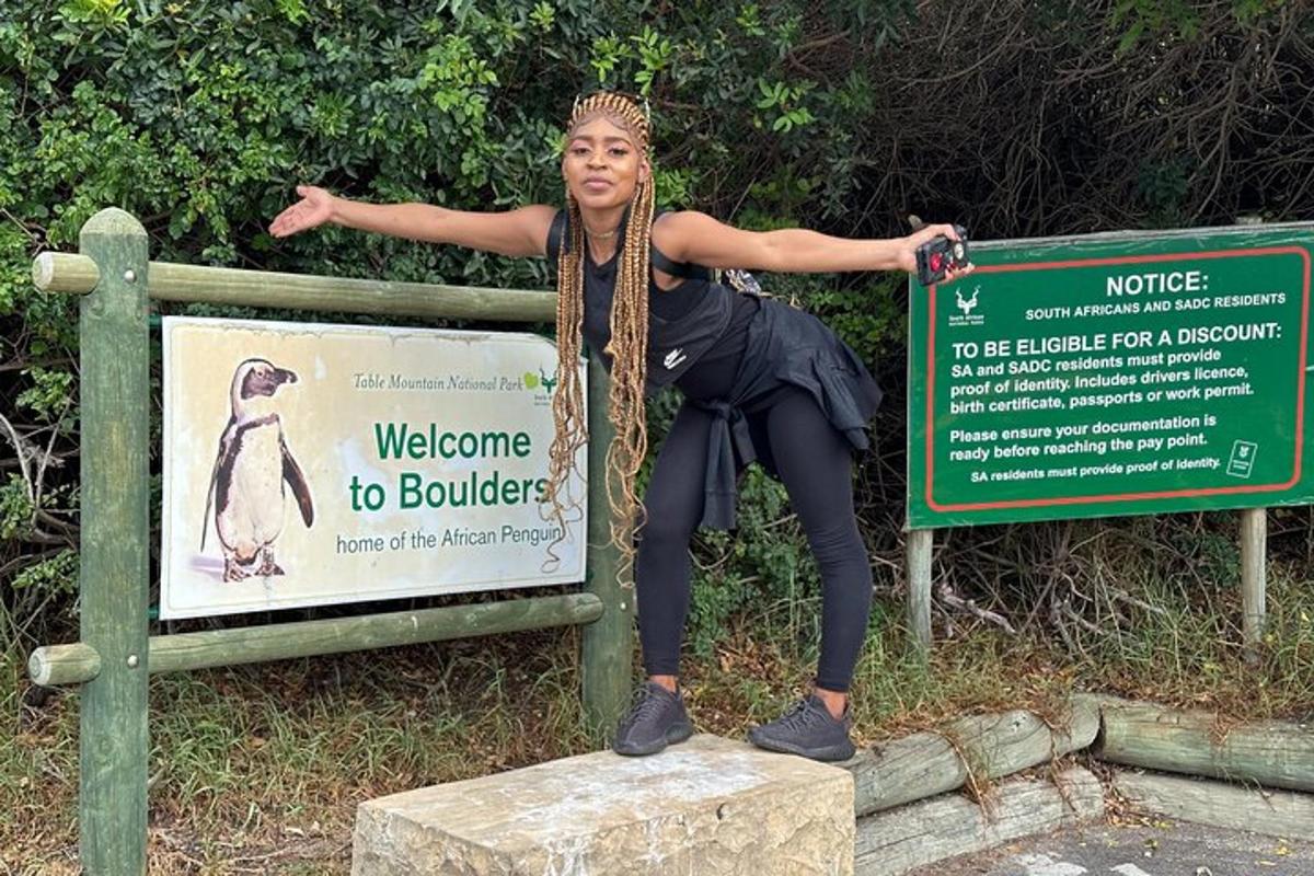 a woman sitting on top of a sign
