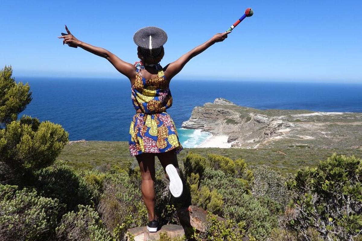 a woman standing on top of a cliff with her arms outstretched