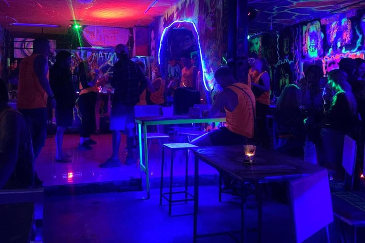 a group of people in a bar with purple lights