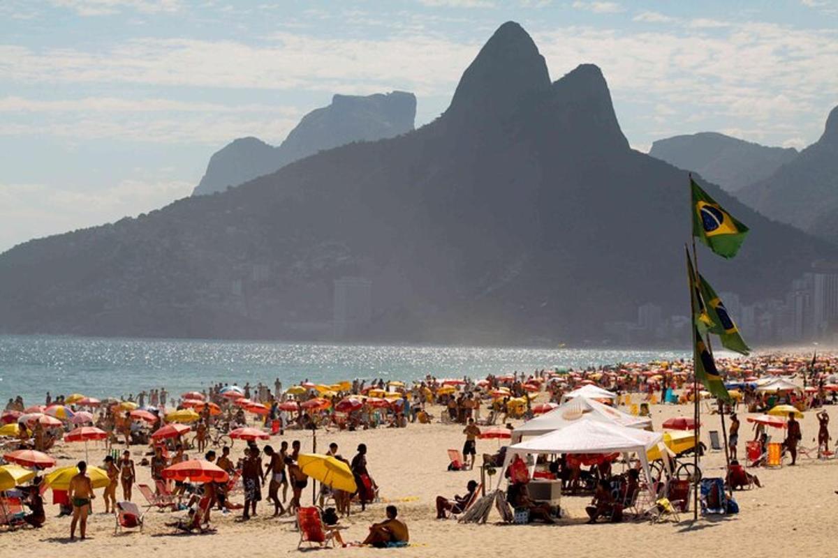 un folto gruppo di persone su una spiaggia con ombrelloni
