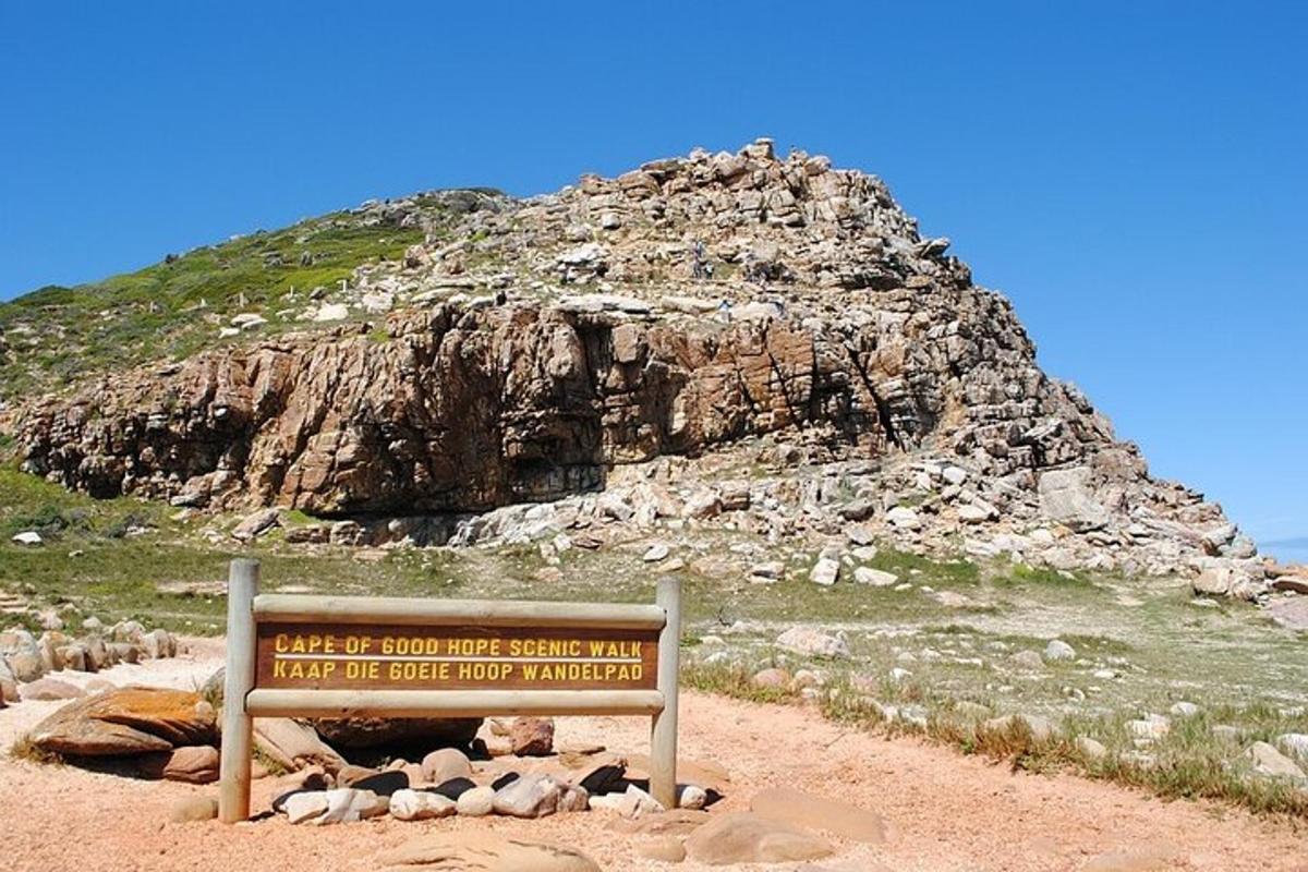 un cartello di fronte a una grande montagna rocciosa