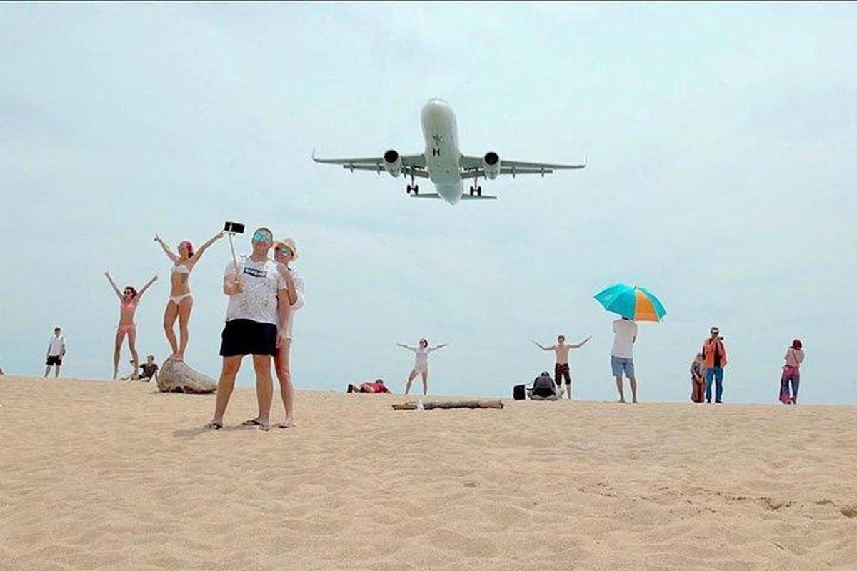 kapal terbang yang terbang di atas pantai dengan orang di atasnya