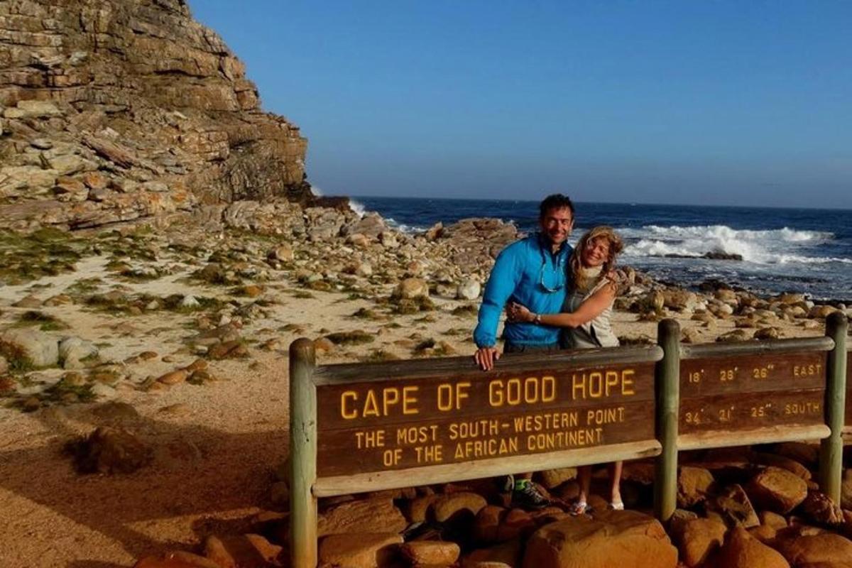 un uomo e una donna in piedi su un cartello sulla spiaggia