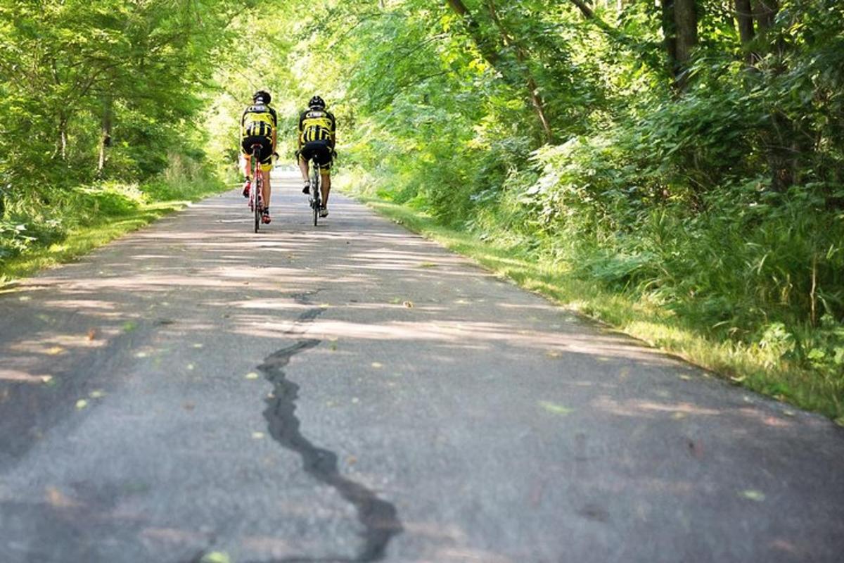 two people riding bikes down a road
