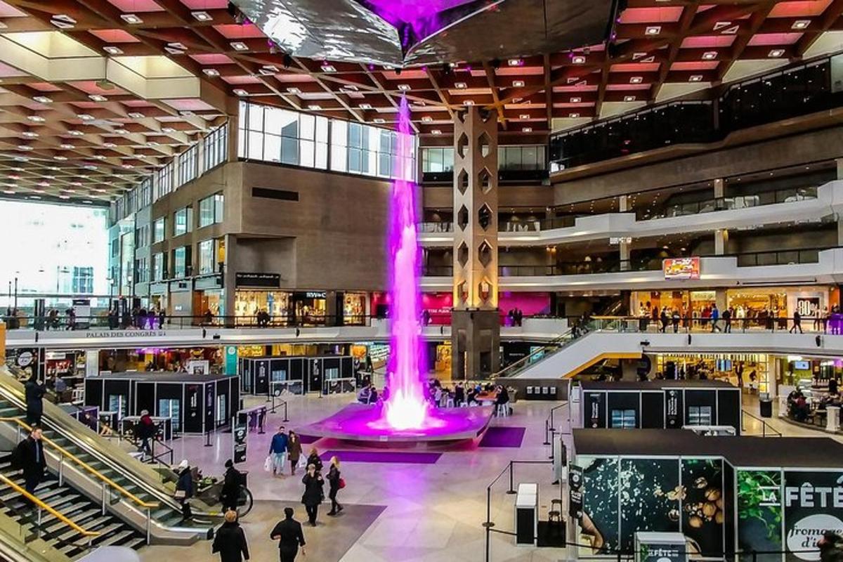 a large shopping mall with a purple fountain in the middle